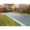 Bache de piscine tension sandow sur sardines plantées dans le sol