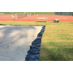 Équipe technique positionnant la bâche de protection au sol avant le montage de la tente stretch nomade.
